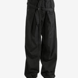 Black pants worn by a person, showing the pants' fit