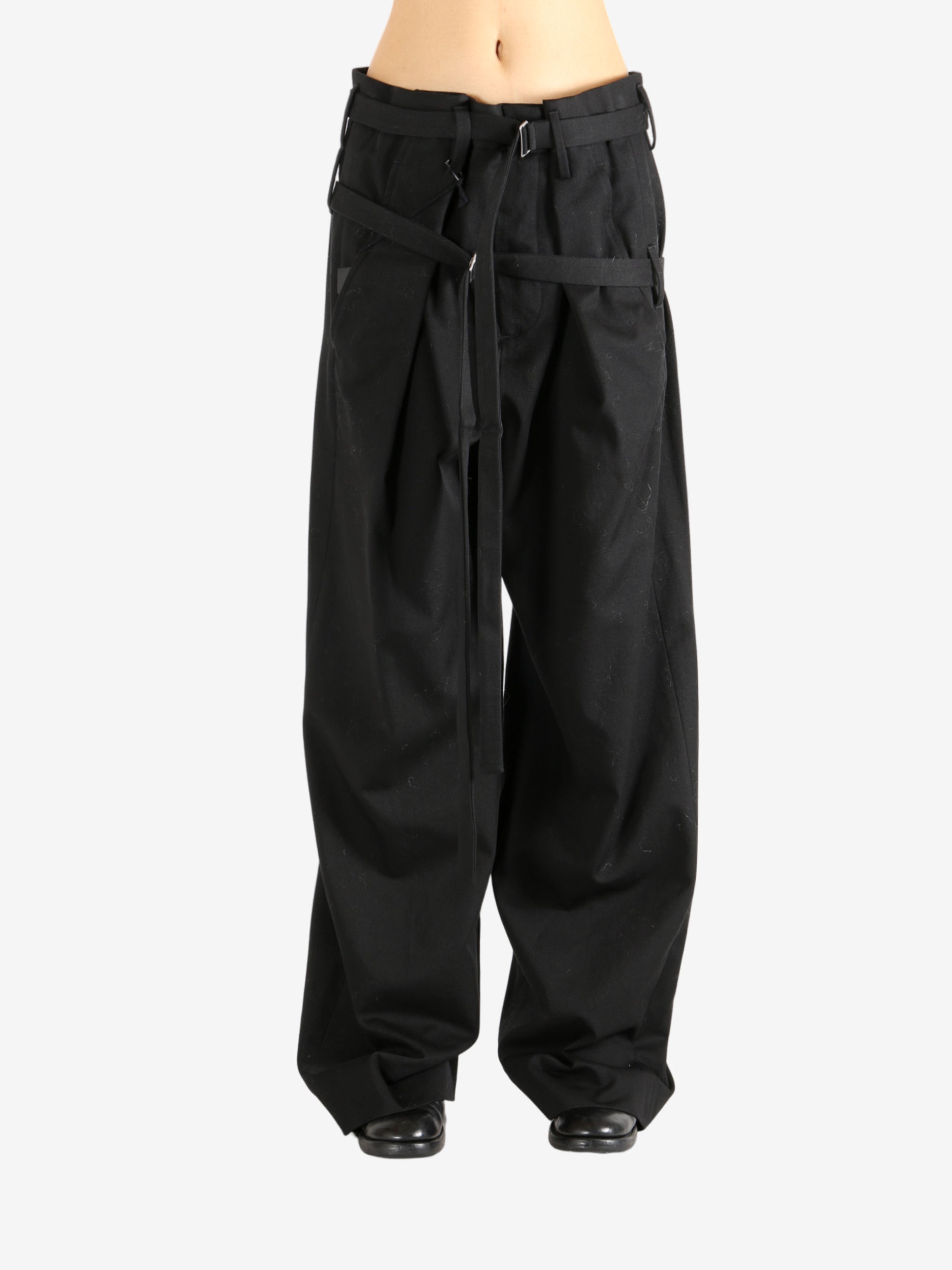 Black pants worn by a person, showing the pants' fit