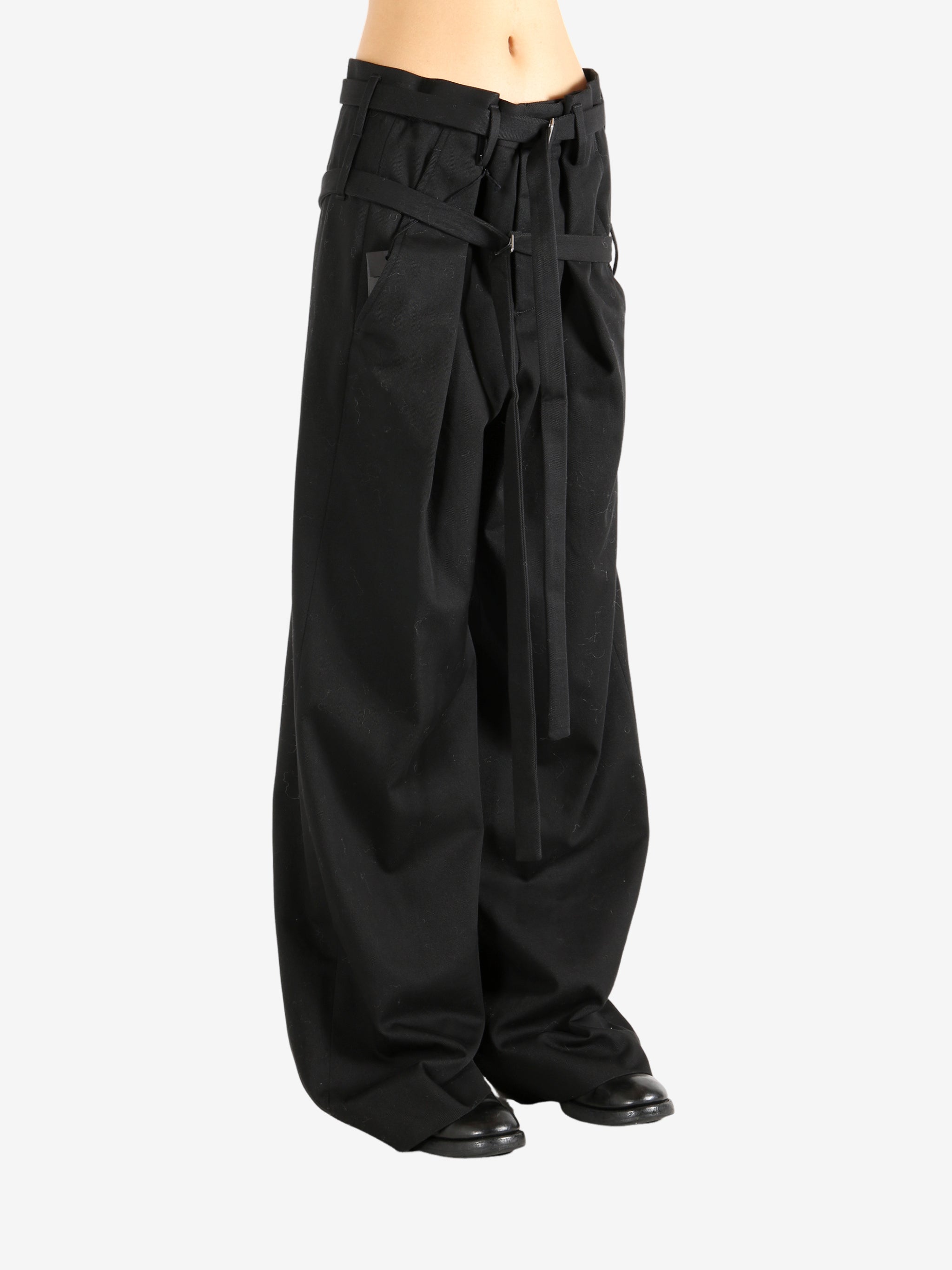 Black pants worn by a person, showing the pants' fit