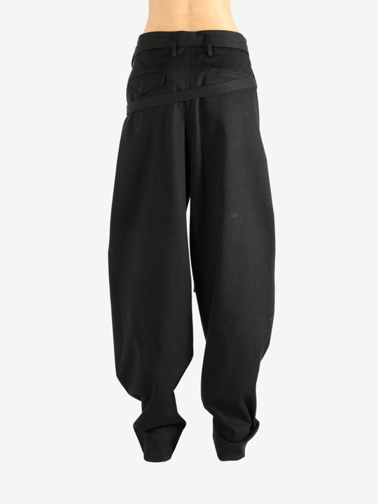 Black pants worn by a person, showing the pants' fit