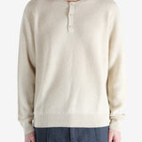 Beige sweater worn by a person, showing the knitwear fit