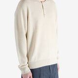 Beige sweater worn by a person, showing the knitwear fit