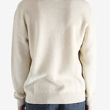 Beige sweater worn by a person, showing the knitwear fit