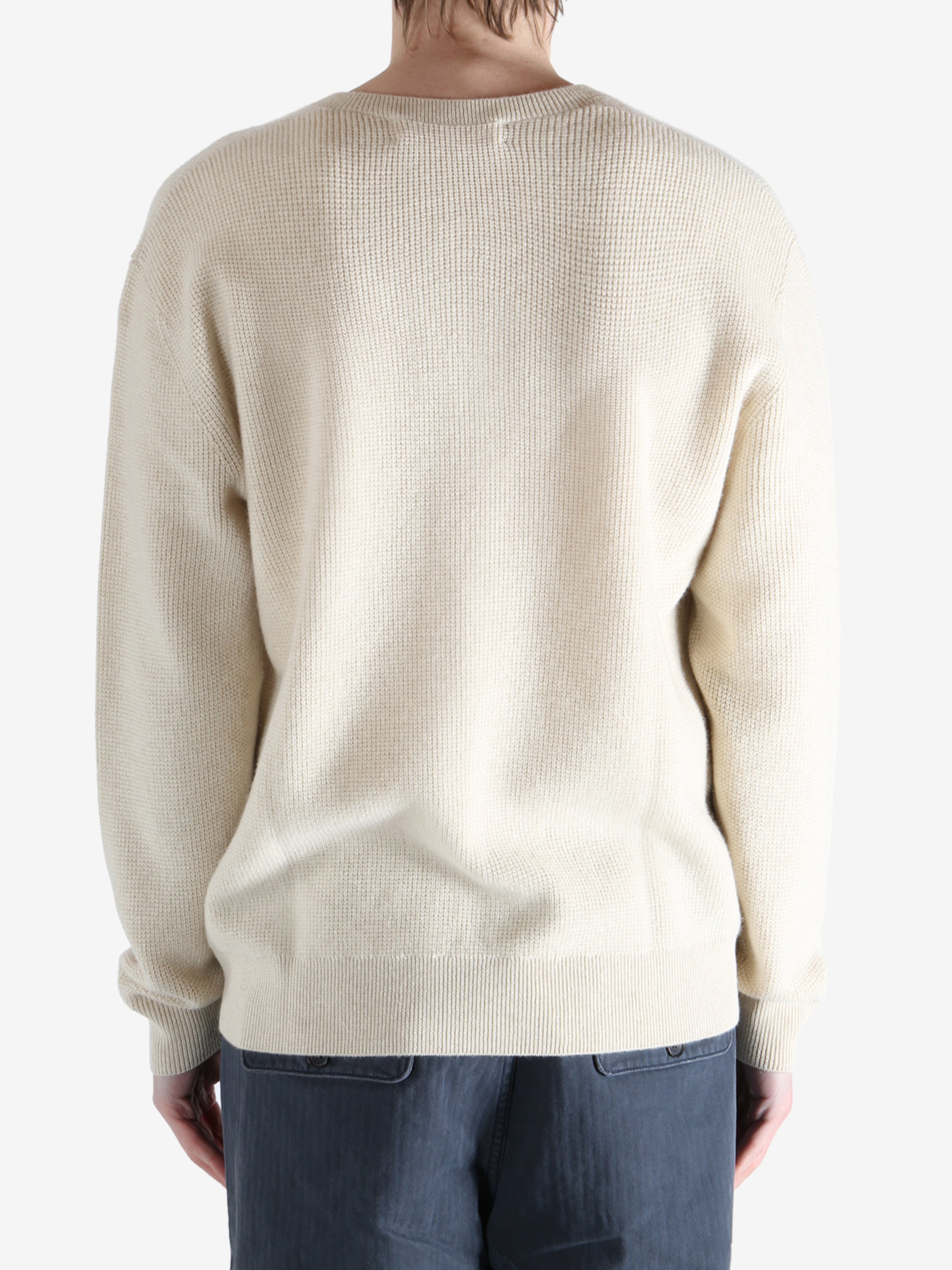 Beige sweater worn by a person, showing the knitwear fit