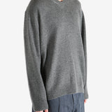 Gray sweater worn by a person, showing the sweater's fit