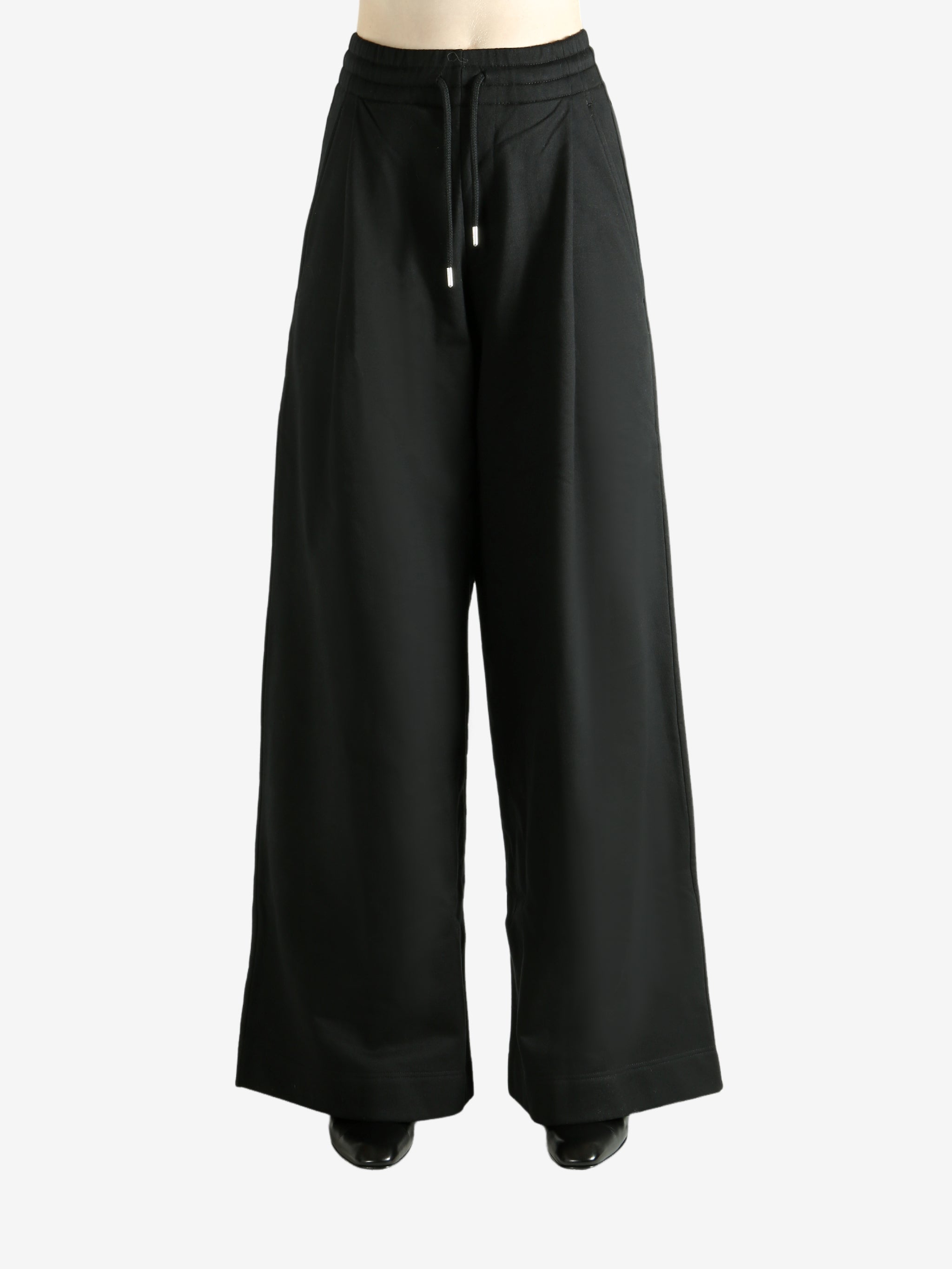 Black pants worn by a person, showing the pants' fit