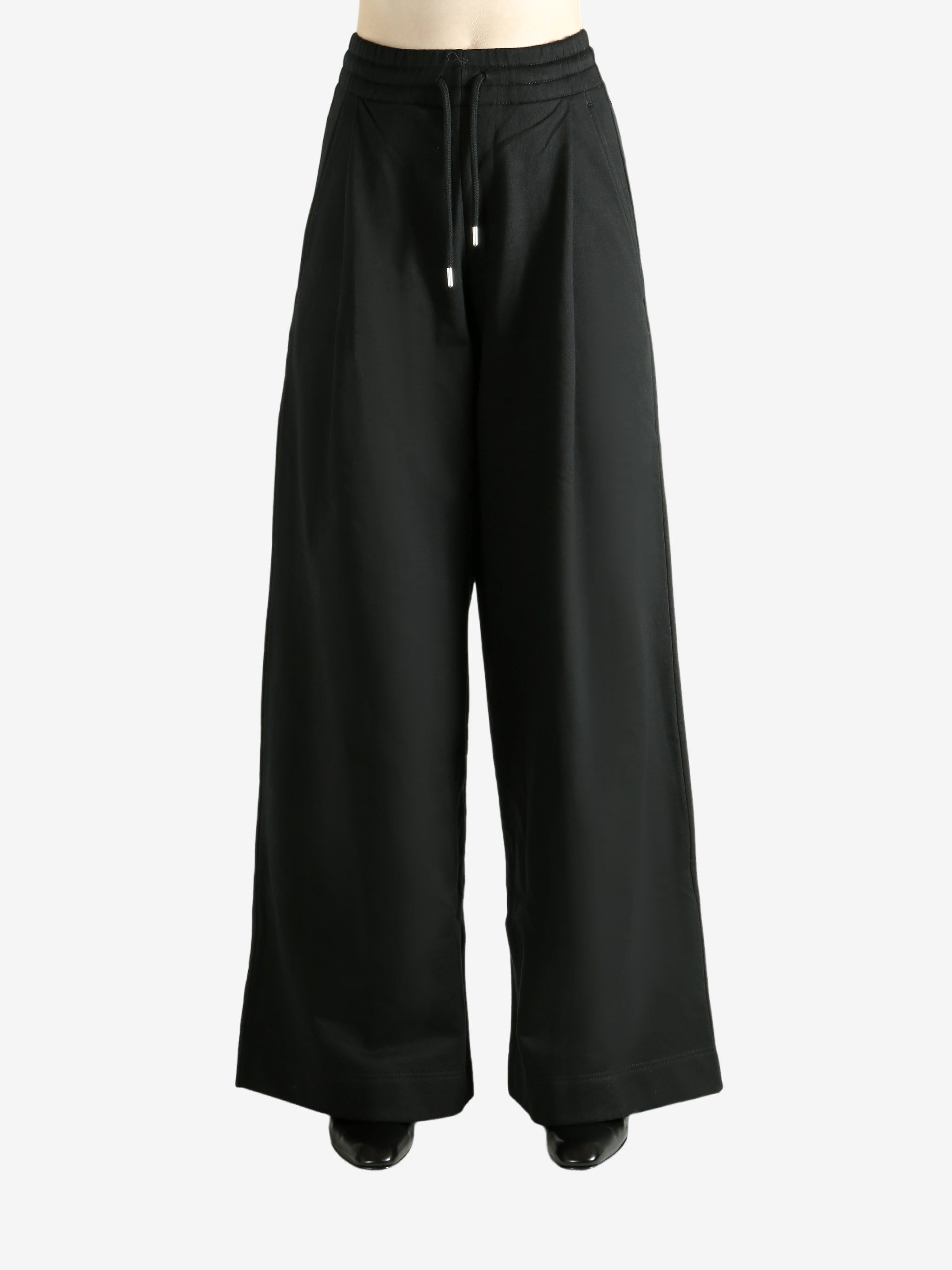 Black pants worn by a person, showing the pants' fit