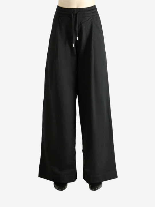 Black pants worn by a person, showing the pants' fit