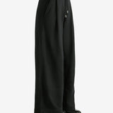 Black pants worn by a person, showing the pants' fit