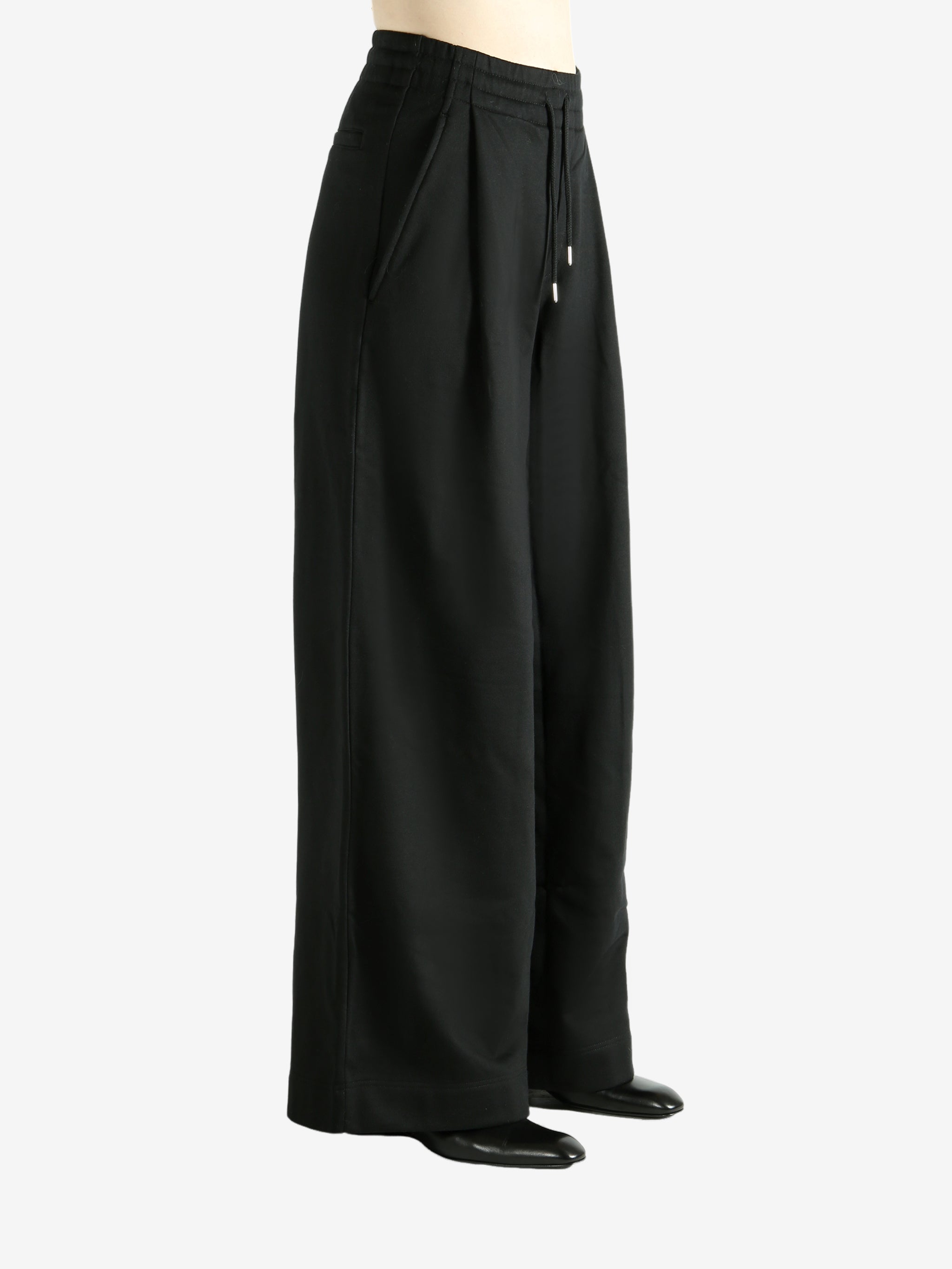 Black pants worn by a person, showing the pants' fit