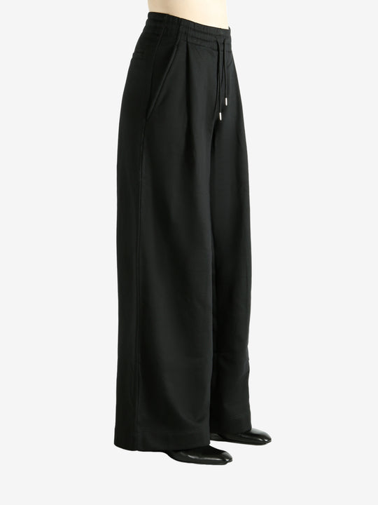 Black pants worn by a person, showing the pants' fit