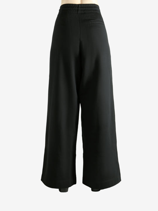 Black pants worn by a person, showing the pants' fit