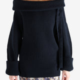 Black sweater worn by a person, showing the sweater's fit