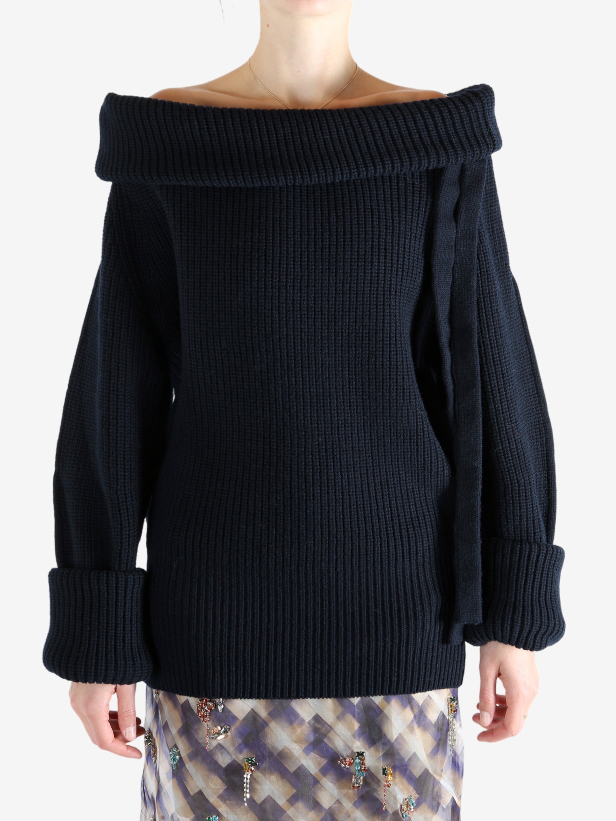 Black sweater worn by a person, showing the sweater's fit