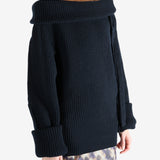 Black sweater worn by a person, showing the sweater's fit