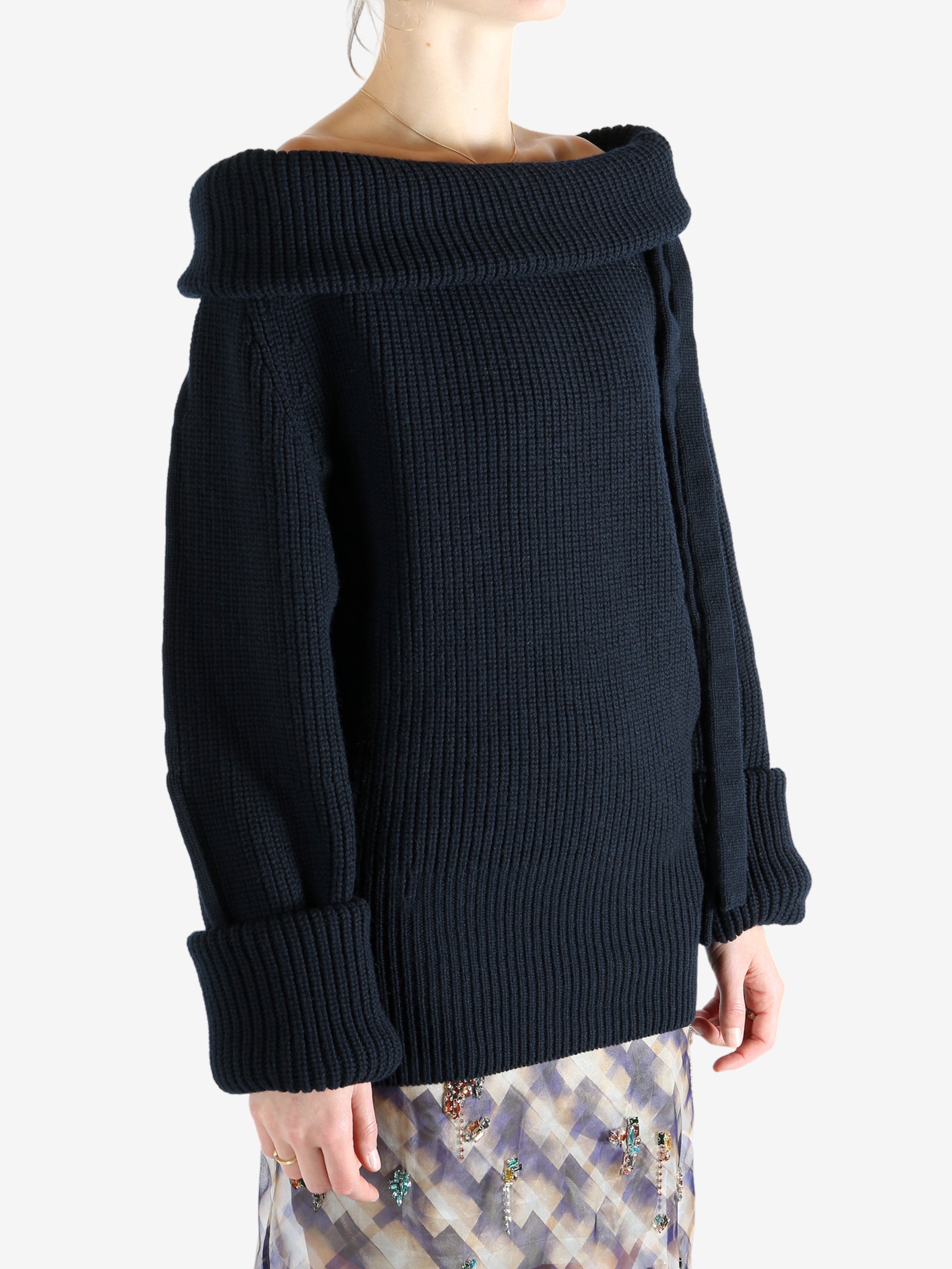 Black sweater worn by a person, showing the sweater's fit