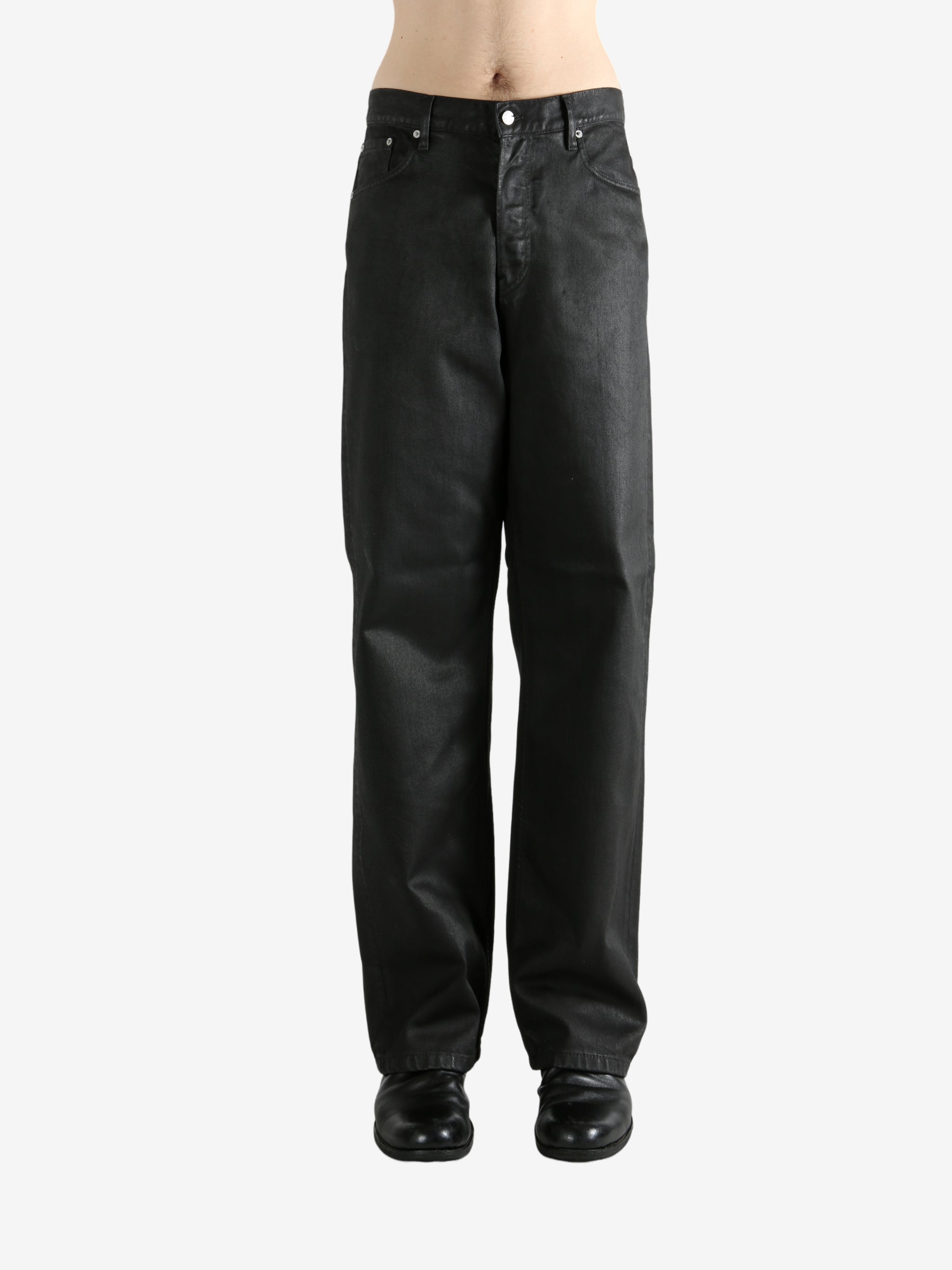 Black pants worn by a person, showing the pants' fit