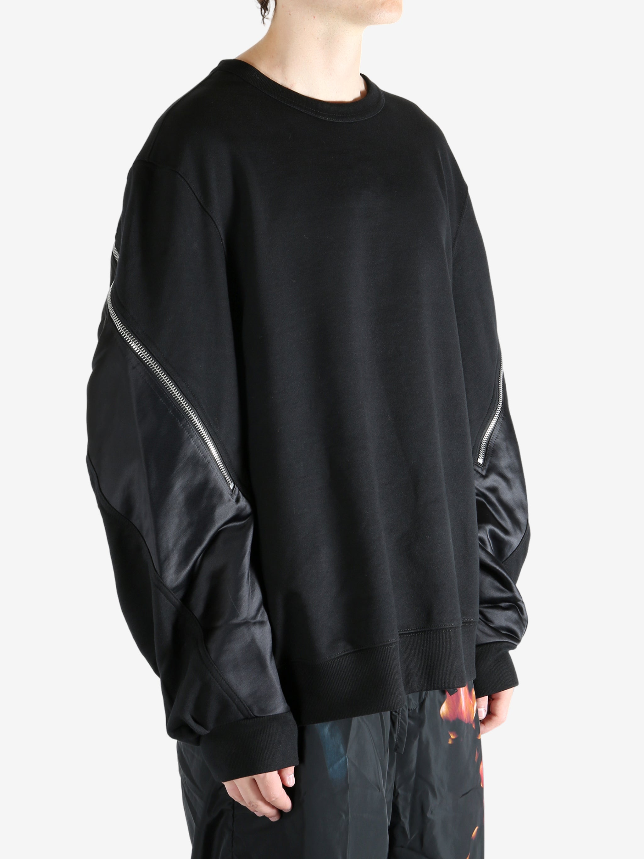 Black sweater worn by a person, showing the sweater's fit