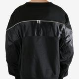 Black sweater worn by a person, showing the sweater's fit