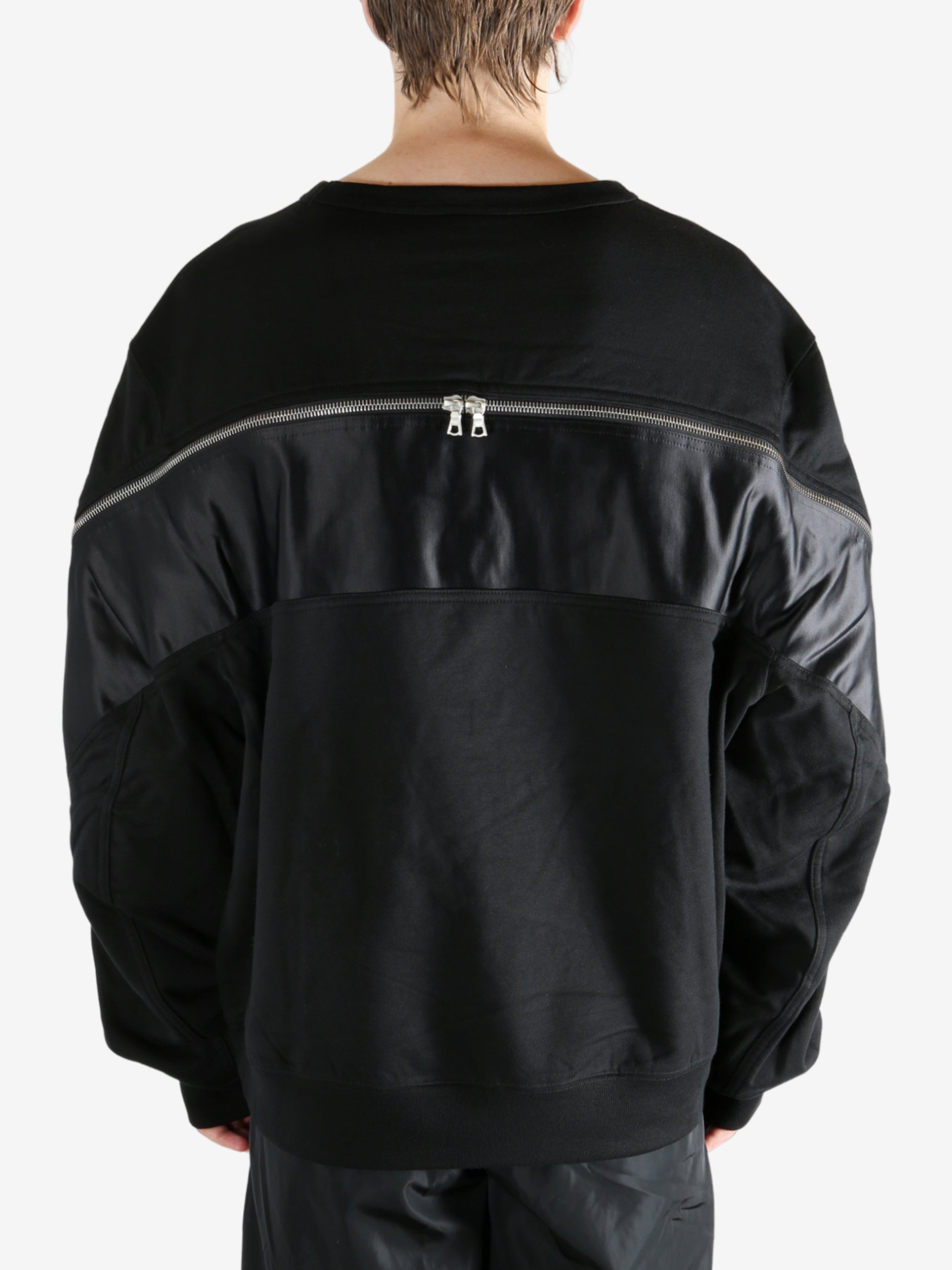 Black sweater worn by a person, showing the sweater's fit