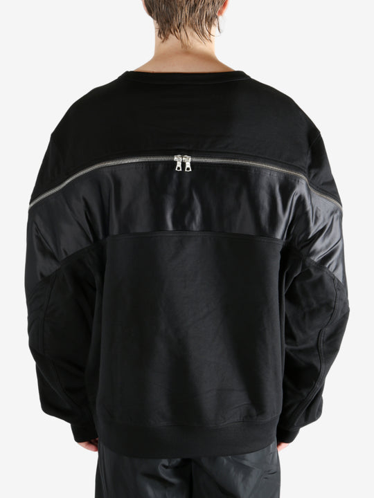 Black sweater worn by a person, showing the sweater's fit