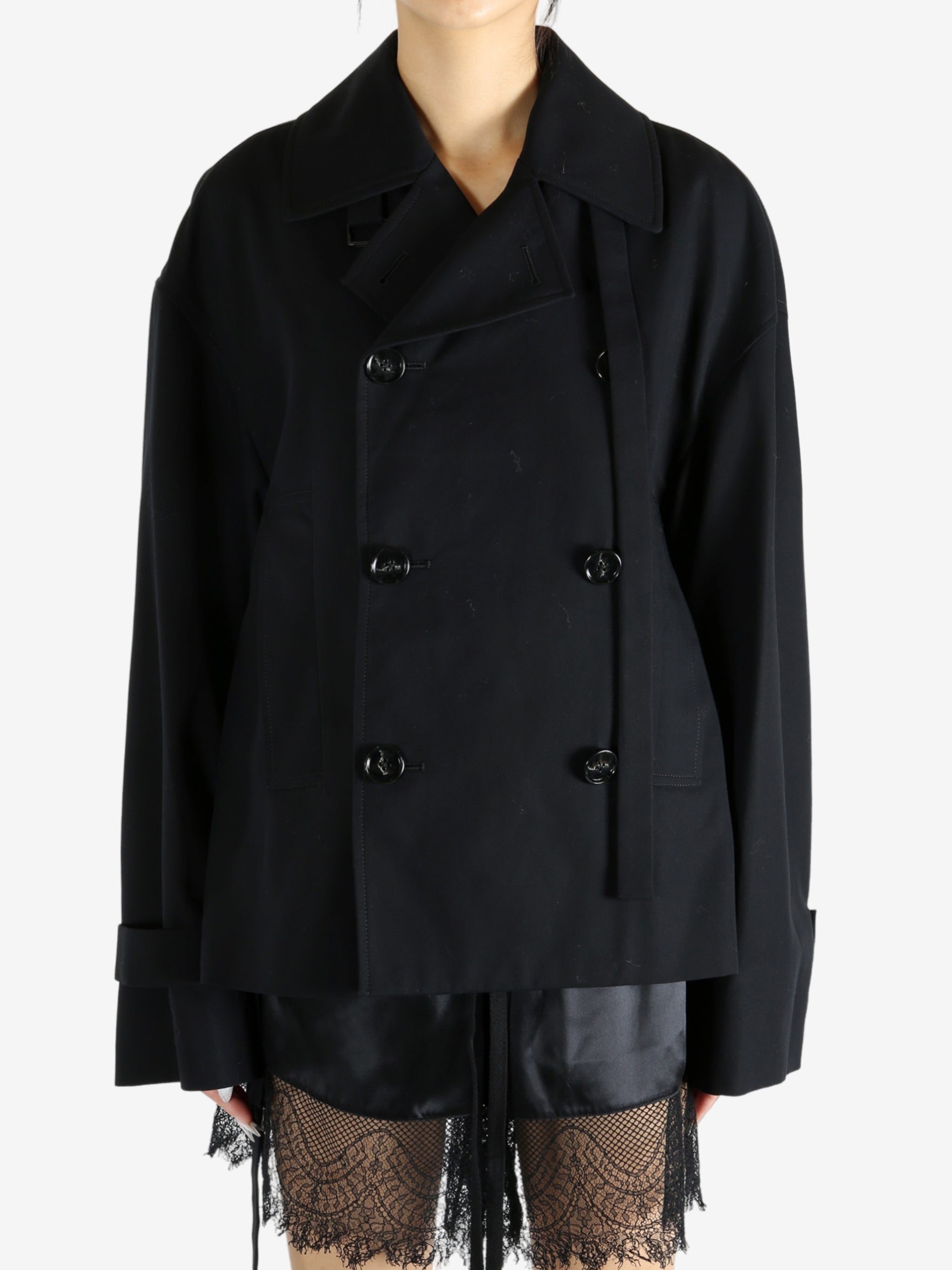 Black coat worn by a person, showing the coat's fit