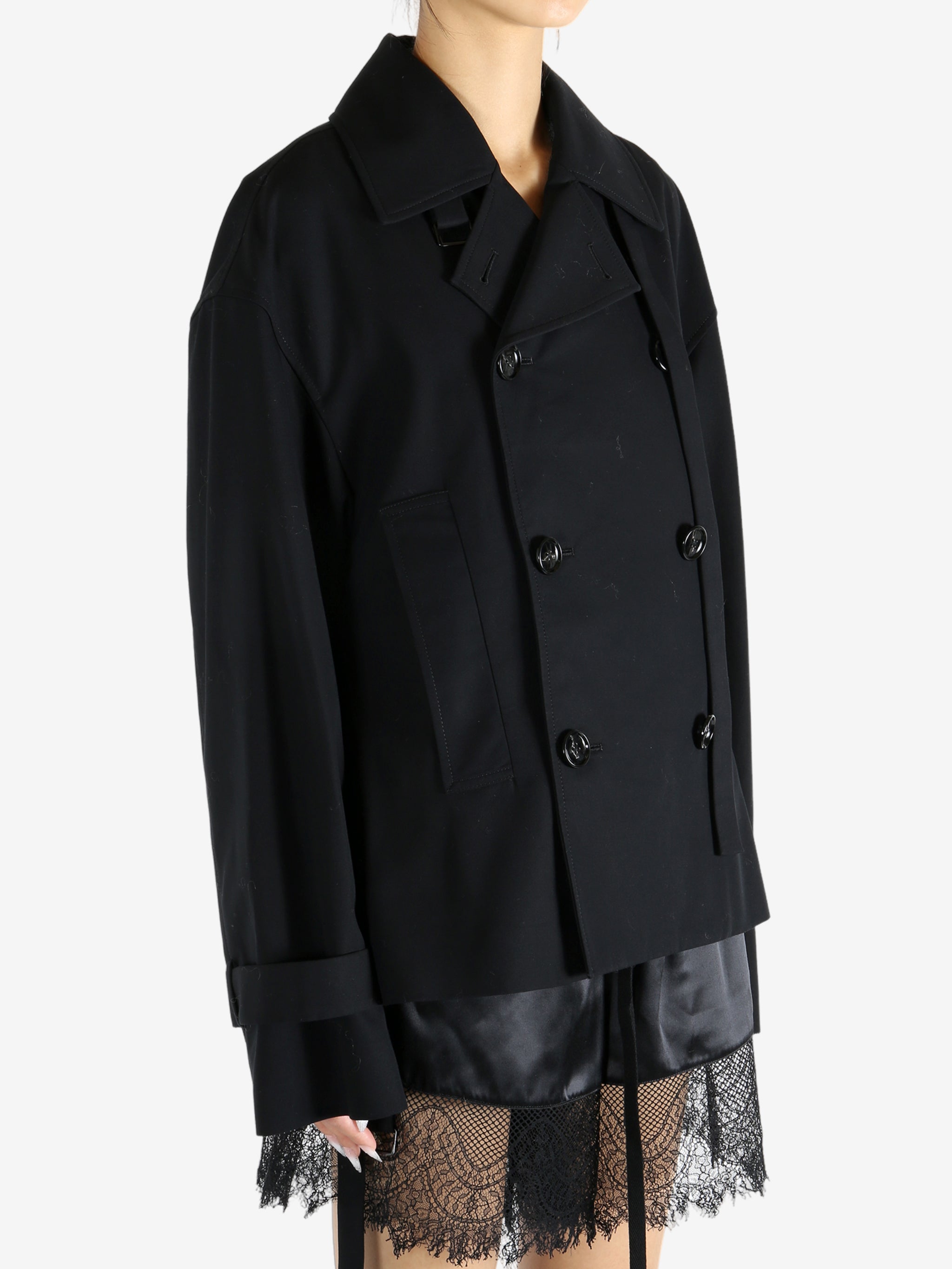 Black coat worn by a person, showing the coat's fit