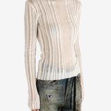 White sweater worn by a person,showing the sweater's fit