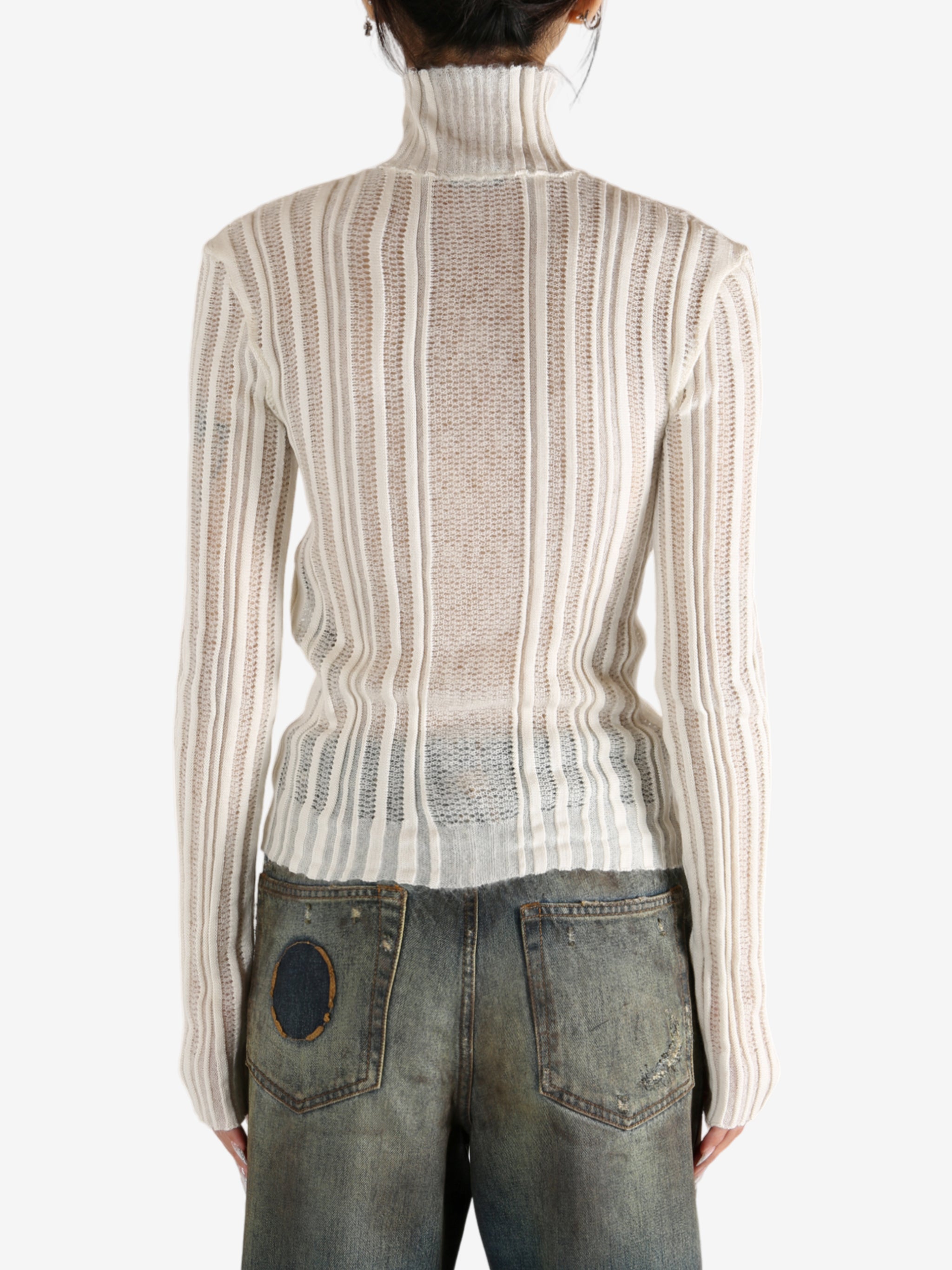 White sweater worn by a person,showing the sweater's fit