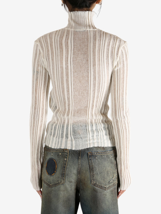 White sweater worn by a person,showing the sweater's fit