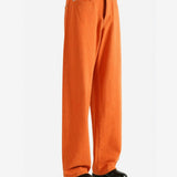 Orange jeans worn by a person,showing the jeans fit