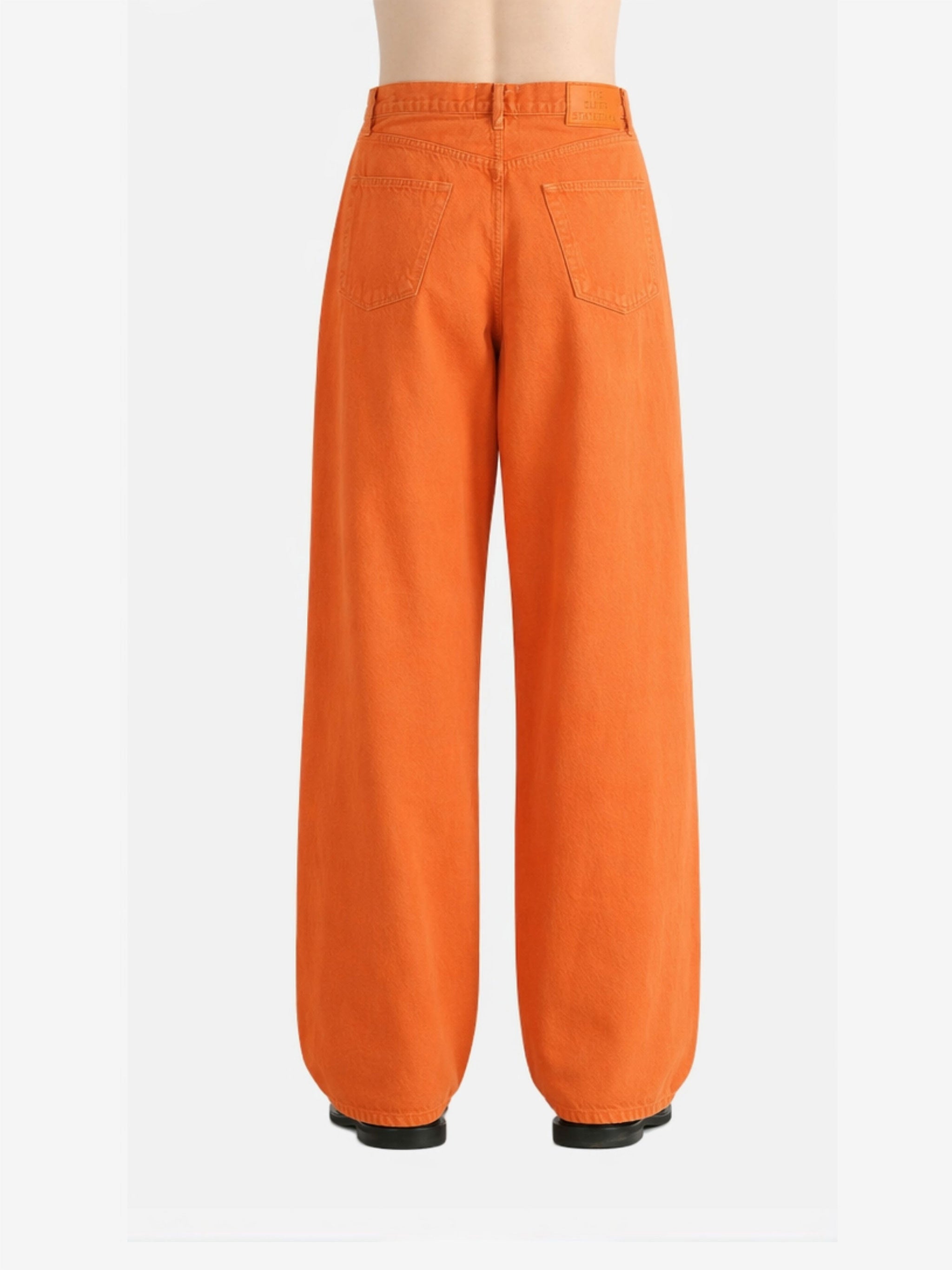 Orange jeans worn by a person,showing the jeans fit