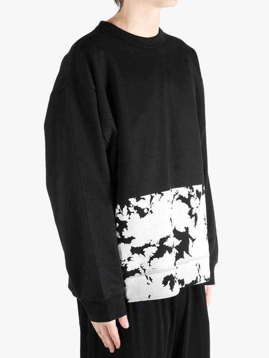 Black sweatshirt worn by a person, showing the sweatshirt's fit