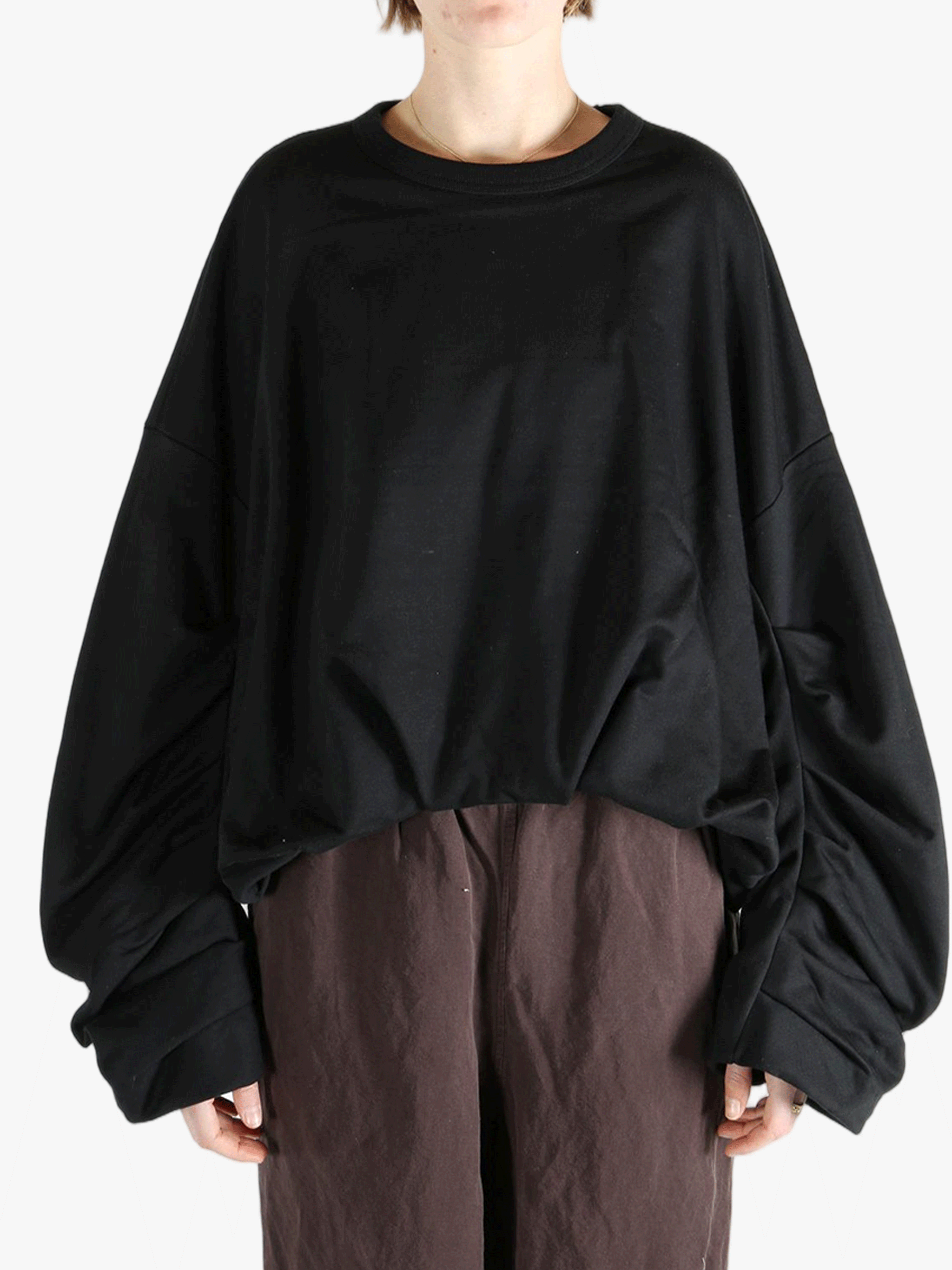 Black sweater worn by a person, showing the sweater's fit