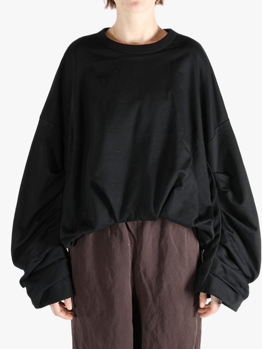 Black sweater worn by a person, showing the sweater's fit