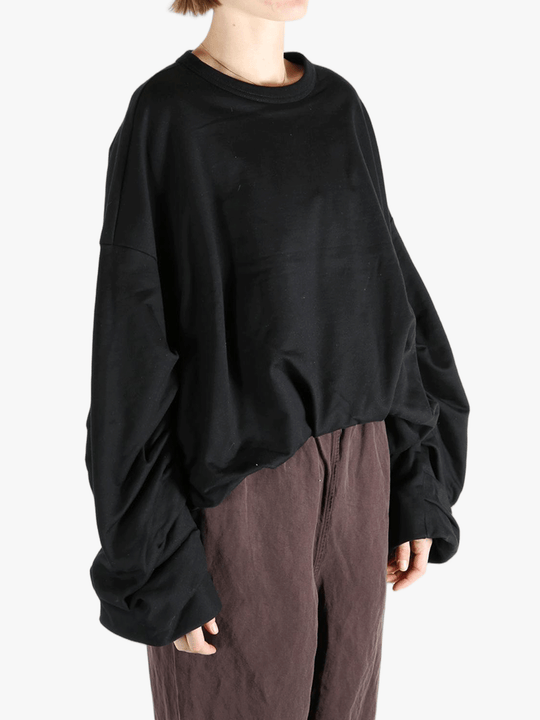 Black sweater worn by a person, showing the sweater's fit