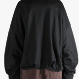 Black sweater worn by a person, showing the sweater's fit
