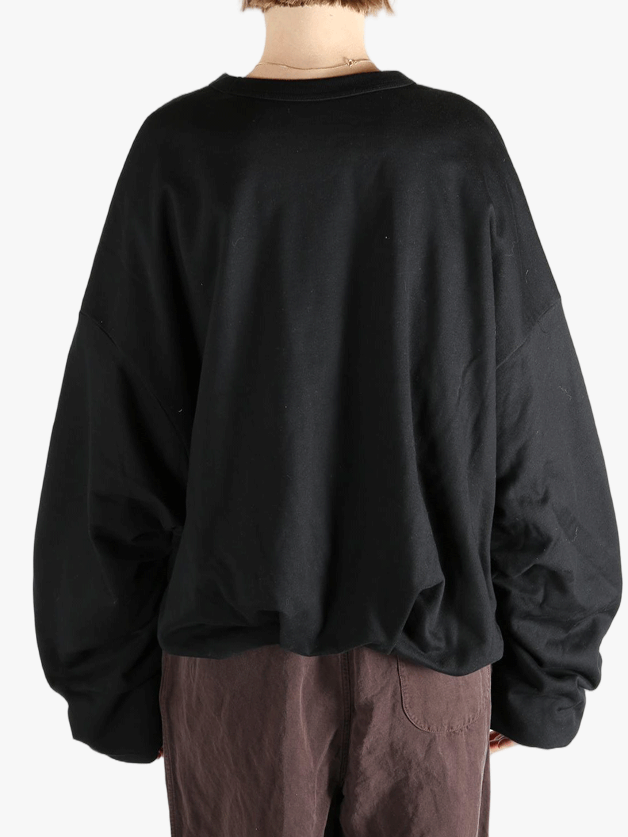 Black sweater worn by a person, showing the sweater's fit