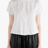 White top worn by a person, showing the top's fit