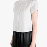 White top worn by a person, showing the top's fit