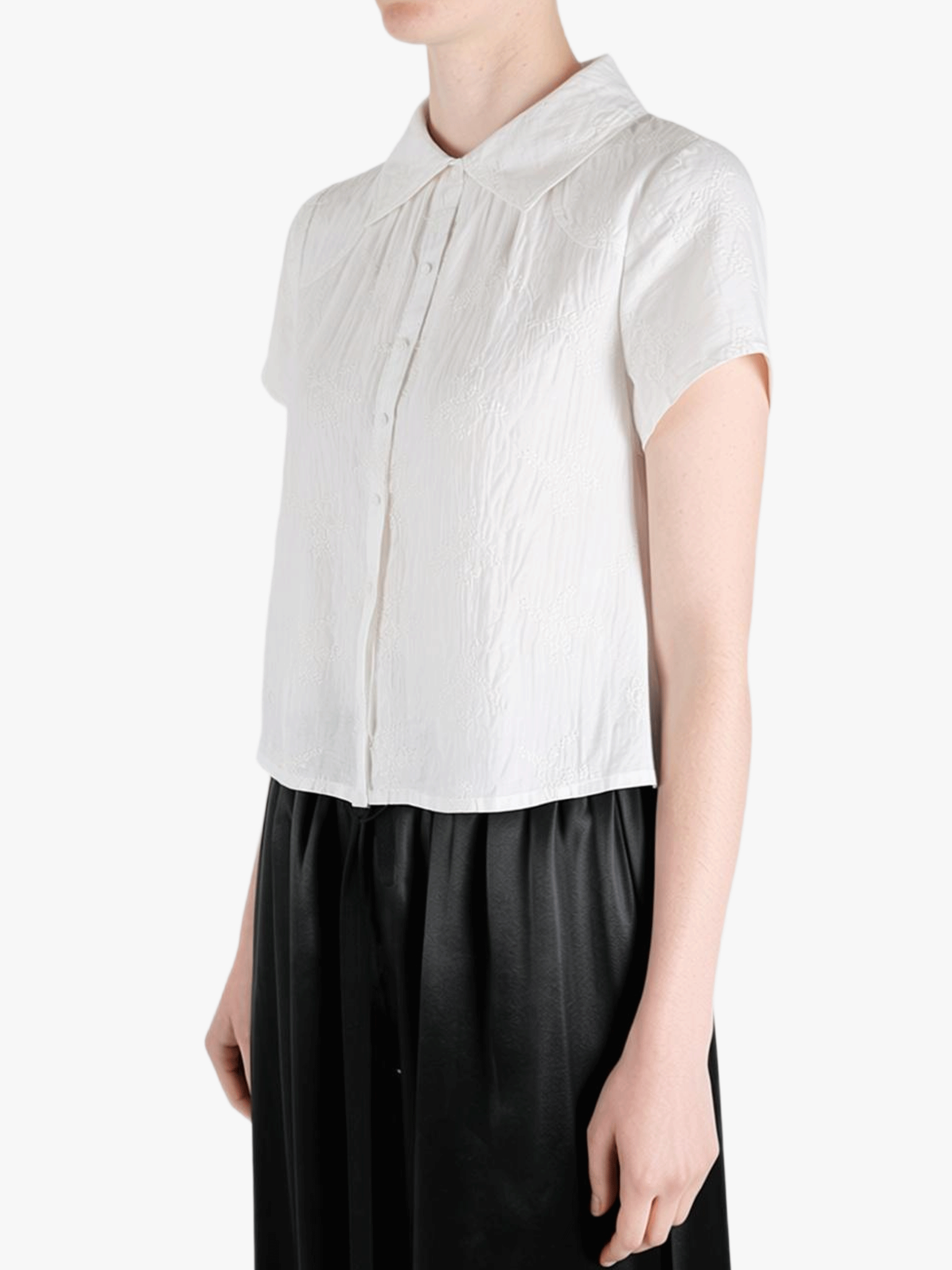 White top worn by a person, showing the top's fit