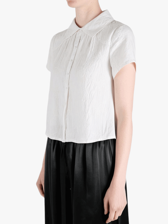White top worn by a person, showing the top's fit