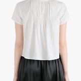 White top worn by a person, showing the top's fit