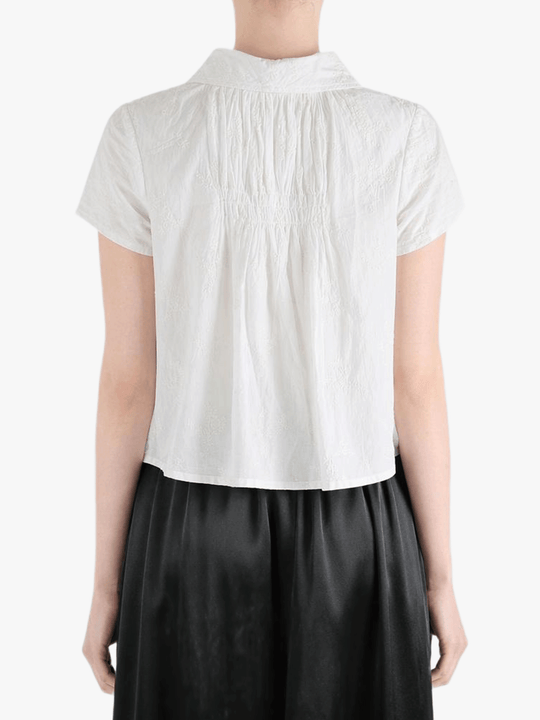 White top worn by a person, showing the top's fit