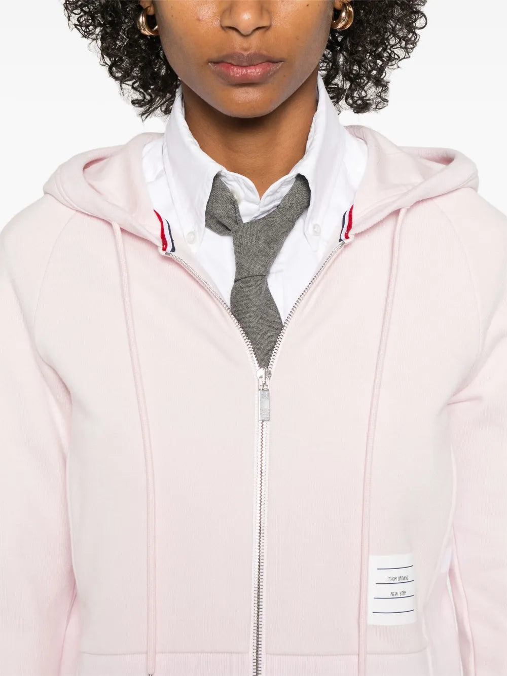 Pink hoodie worn by a person, showing the hoodie's fit