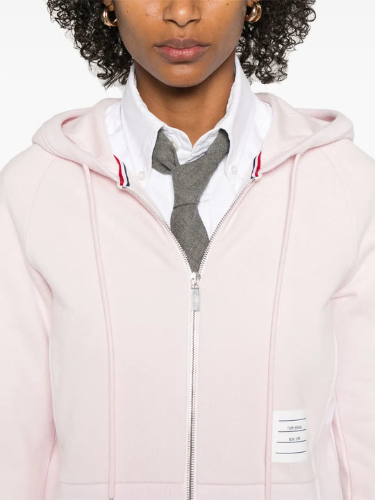Pink hoodie worn by a person, showing the hoodie's fit