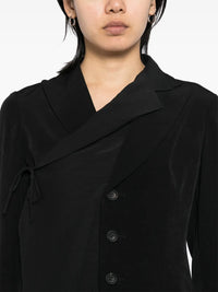 Close up of black coats, showing texture of the triacetate fabric.