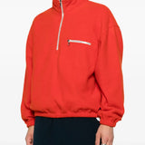 Orange knitwear worn by a person, showing the knitwear's fit