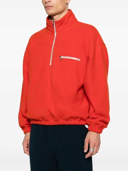 Orange knitwear worn by a person, showing the knitwear's fit