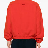 Orange knitwear worn by a person, showing the knitwear's fit